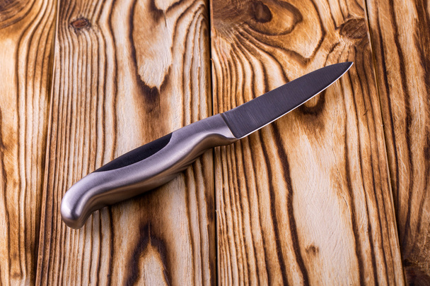 блестящий металлический кухонный нож на деревянном столе
 - Фото, изображение
