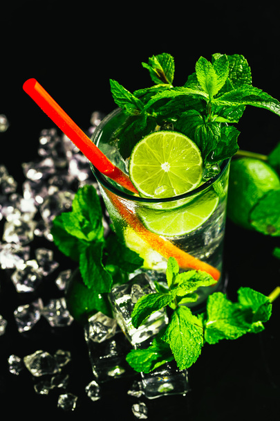 glass of mojito with lime and mint ice cube close-up red straw - Φωτογραφία, εικόνα