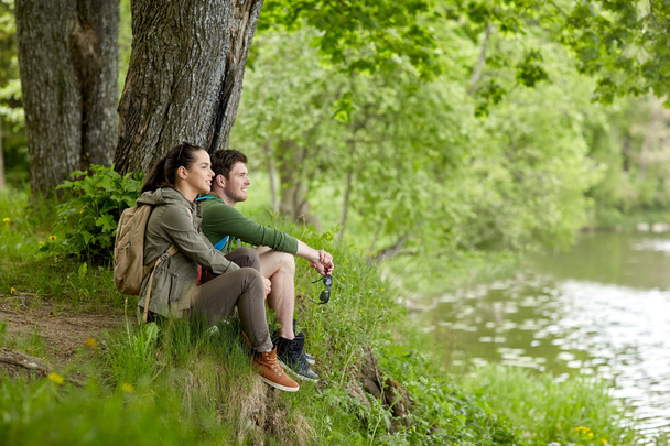 smiling couple with backpacks in nature - Foto, Imagem