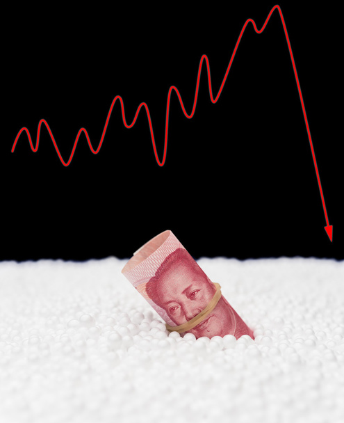 RMB paper currency sink into polystyrene particle and a fluctuation graphic on background monetary concept - Photo, Image