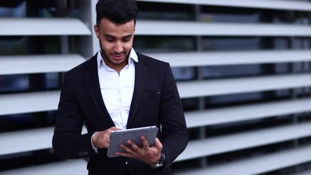 Ο άνθρωπος στο κοστούμι Αραβικά με Tablet κοντά στο επιχειρηματικό σημείο δάχτυλο στο Tablet - Πλάνα, βίντεο