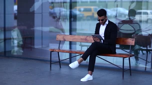Uomo in abito arabo con tablet vicino agli affari
 - Filmati, video