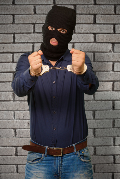 Злой преступник, запертый в наручниках
 - Фото, изображение