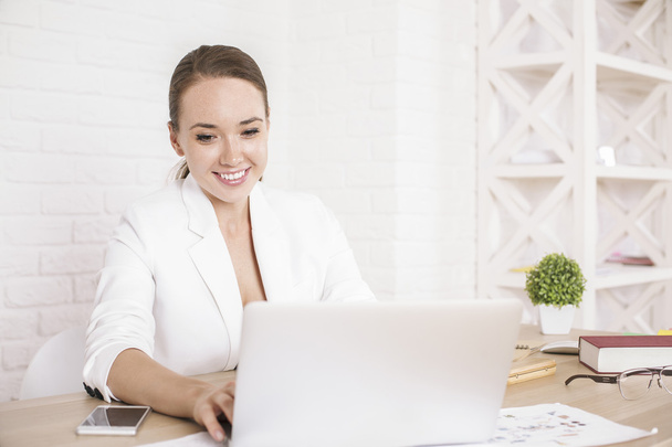 Happy businesswoman using laptop - Foto, afbeelding