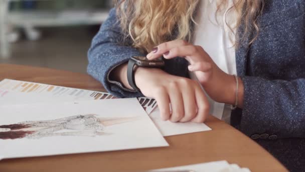 A young woman artist making gestures on a wearable smartwatch computer device - Metraje, vídeo