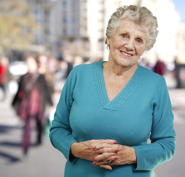 портрет пожилой женщины, стоящей в переполненном месте
 - Фото, изображение