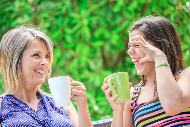 Mutter und Tochter entspannen sich zu Hause und trinken Tee - Foto, Bild
