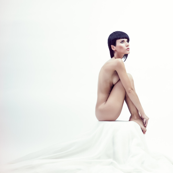 Nude beautiful sitting woman in white room - Foto, imagen