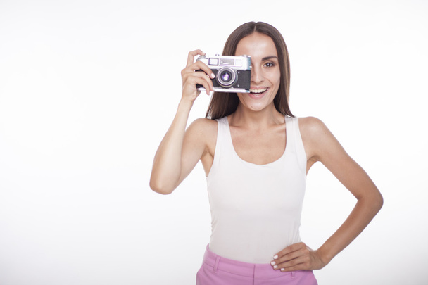 Girl with a camera in hand smiling. - Valokuva, kuva