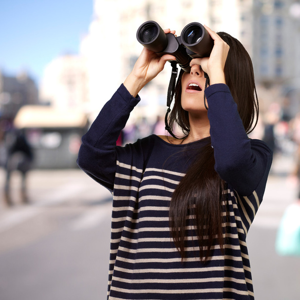 retrato de menina olhando através de um binóculos na cidade
 - Foto, Imagem
