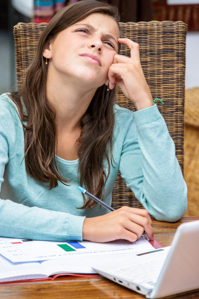 beautiful girl student doing her homework pensively - Photo, Image