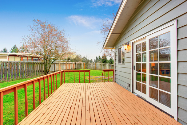 Uma casa de história com deck de madeira com vista para o jardim do quintal
. - Foto, Imagem