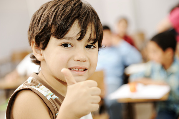 Glücklicher Junge im Klassenzimmer mit erhobenem Daumen - Foto, Bild