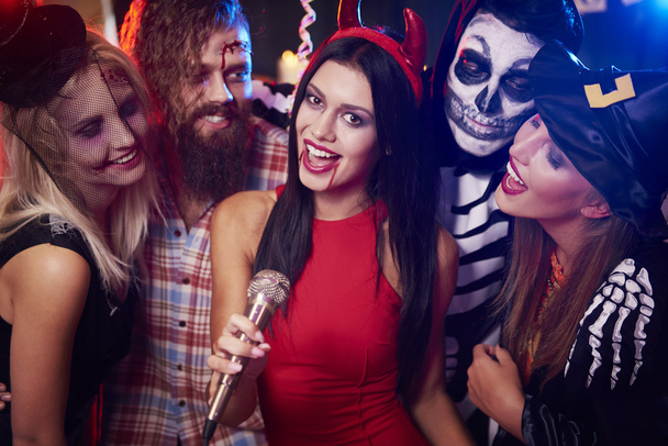 Grupo de amigos cantando karaoke en la fiesta
   - Foto, Imagen