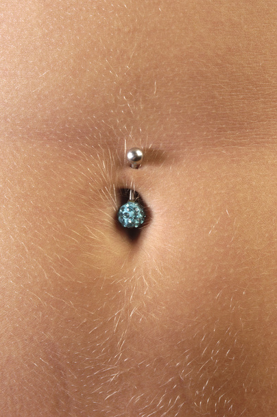 λεπτομέρεια από ένα piercing στην κοιλιά της ένα κορίτσι - Φωτογραφία, εικόνα