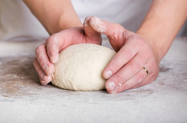 Fermer la main d'un boulanger pétrissant et façonnant la pâte
 - Photo, image