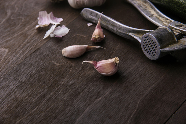Garlic background. Fresh  and  press. On dark brown rustic . - Фото, изображение