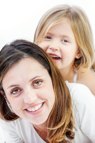 Gros plan d'une jeune femme souriante jouant avec son enfant sur fond blanc
 - Photo, image