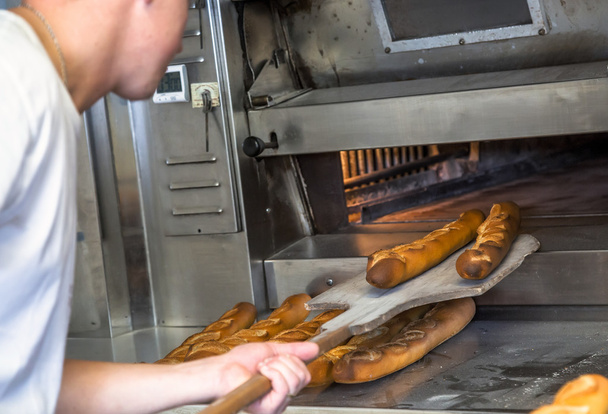 baker removing the oven a delicious crispy golden wand - Φωτογραφία, εικόνα