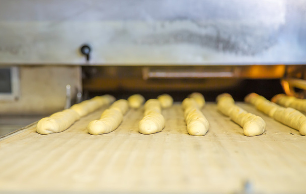 A plain baguette ready to bake on baking tray - Foto, afbeelding