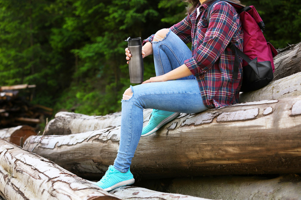 Woman sitting on pile of logs - Photo, Image