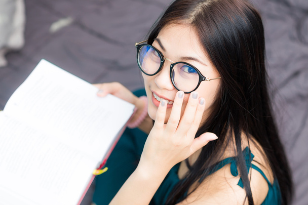 Asiatico nerd donna reading un libro e smiling
 - Foto, immagini