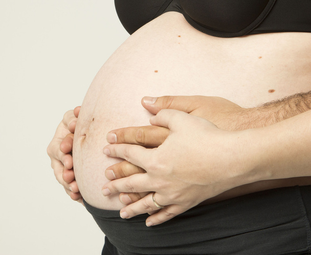 Έγκυος γυναίκα που κρατά τα χέρια στην όμορφη κοιλιά - Φωτογραφία, εικόνα