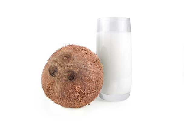 whole coconut and  milk in a glass on  white isolated background - Foto, afbeelding