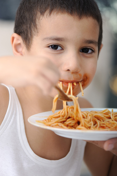 νόστιμο φαγητό, βρώμικο παιδί τρώει μακαρόνια - Φωτογραφία, εικόνα
