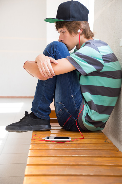 Teenage boy  listening music at school - Foto, afbeelding