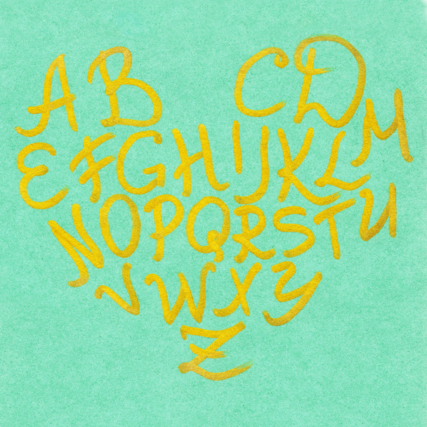 Χρυσό χρυσό σε πράσινο γράμματα σετ τυπογραφία σε σχήμα καρδιάς αλφάβητο - Φωτογραφία, εικόνα