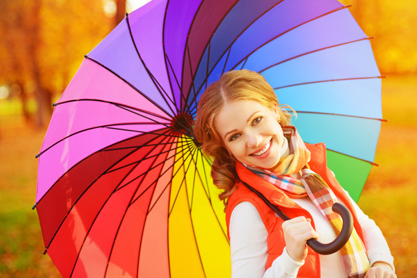 mujer feliz con paraguas multicolor arco iris bajo la lluvia a la par
 - Foto, Imagen