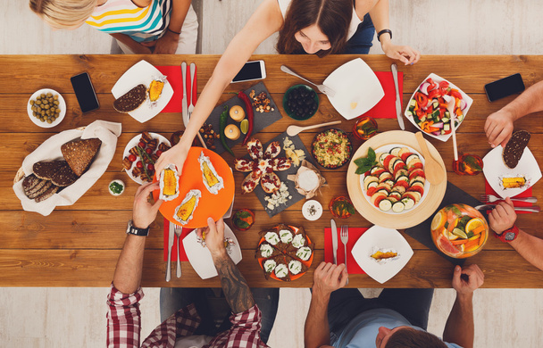 Lidé jíst zdravá jídla na sváteční stůl večerní párty - Fotografie, Obrázek