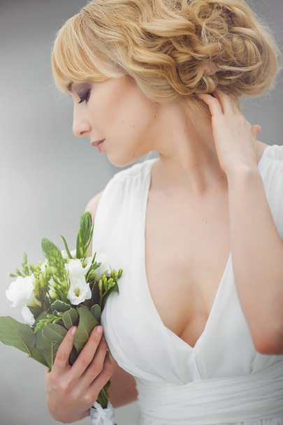 Young beautiful bride with a wedding bouquet. - Foto, afbeelding