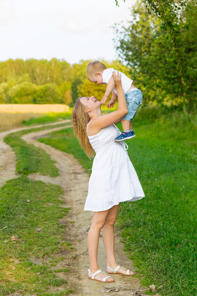 Pregnant mom with a boy resting in a meadow. - 写真・画像