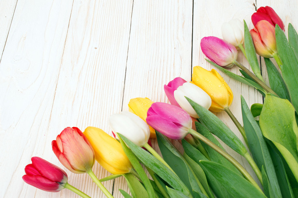 bouquet of tulips on rustic wooden board, easter decoration - Fotó, kép