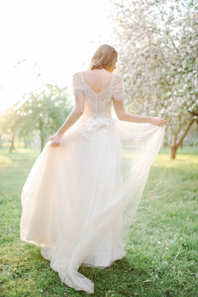 Young beautiful bride portrait in park with flowers - Foto, afbeelding
