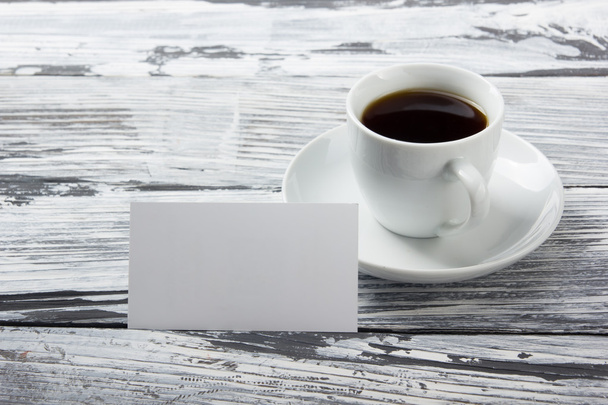 Фото порожніх б-карток з чашкою кави на дерев'яній текстурі. Копіювати простір для вашого оголошення
. - Фото, зображення