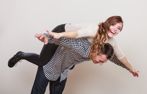 Kobieta jazdy piggyback na człowieka. Szczęśliwa para. - Zdjęcie, obraz