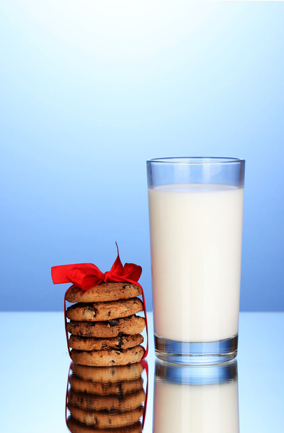 sklenici mléka a soubory cookie na modrém pozadí - Fotografie, Obrázek