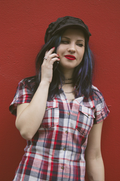 hipster woman with mobile phone on red wall - Photo, image