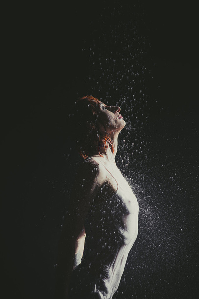 Shower. Girl in a white T-shirt standing under a shower. - Photo, Image