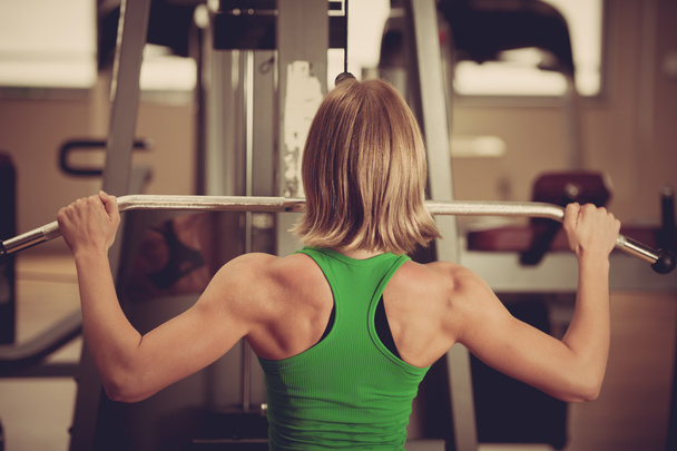 beautiful muscular fit woman exercising building muscles in fitn - Fotó, kép