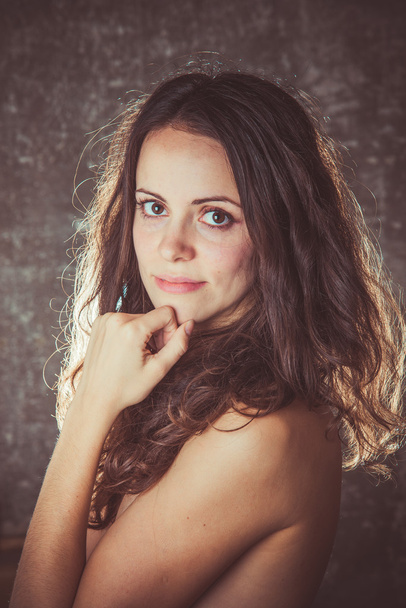 Portrait of a young girl. Brunette with curly long hair. - Foto, Imagen