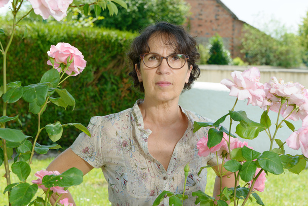femme d'âge moyen avec des lunettes dans le jardin
 - Photo, image