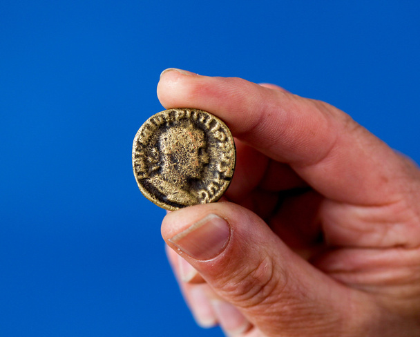 Le dita tengono moneta antica
 - Foto, immagini