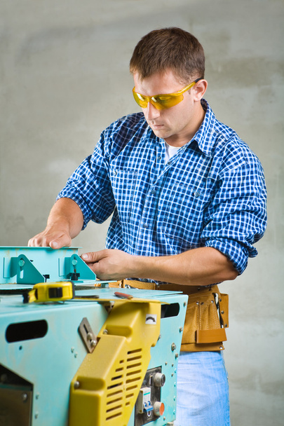 Young men adjusts woodworking mashine - Foto, Bild