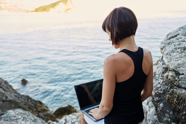Piękna młoda kobieta Freelancer za pomocą laptopa siedzi w pobliżu s - Zdjęcie, obraz