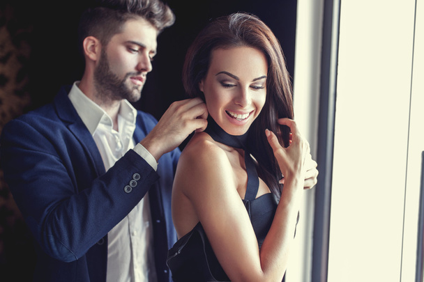 Stylish young man helps woman dressing up  - Фото, зображення