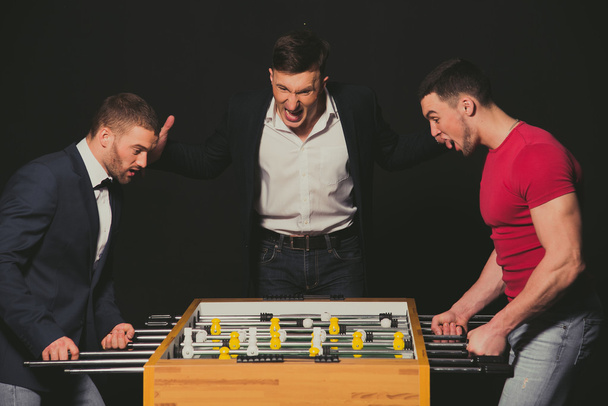Boys play table football. The emotions of winning and losing. - Φωτογραφία, εικόνα